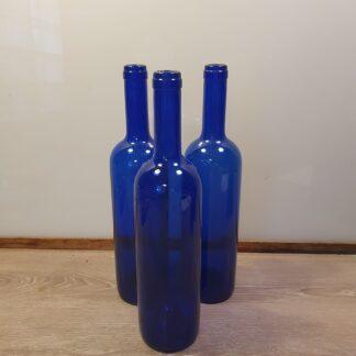 3 blå flasker i glas